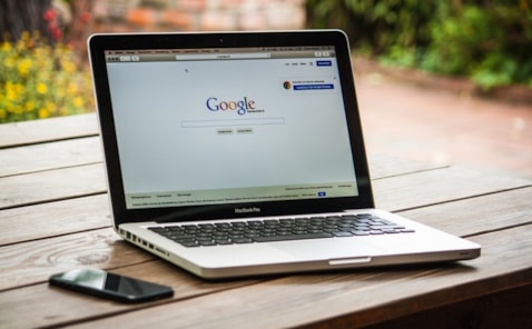 Laptop open on table with Google homepage displaying