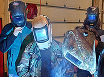 Welding students with helmets on