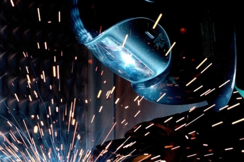 A person welding with a torch and helmet