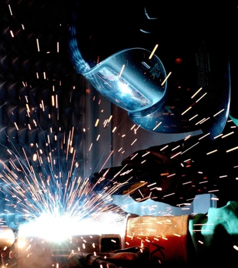 A person welding with a torch and helmet