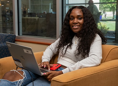 Student with laptop in a chair