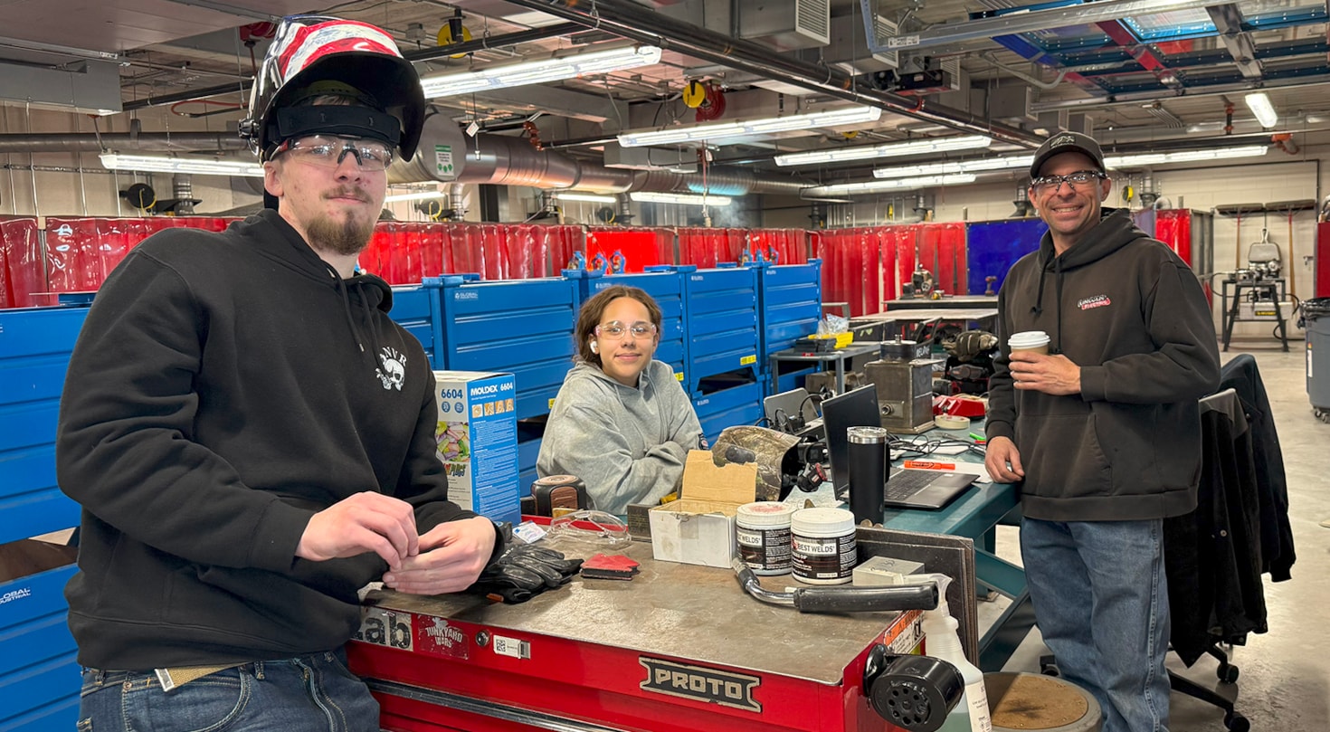 Welding students and instructor looking at camera in IMEC building