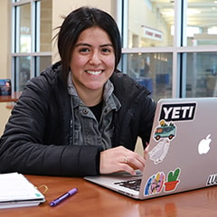 Student at laptop looking at the camera