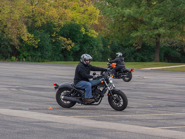 students riding motorcycles in parking lot
