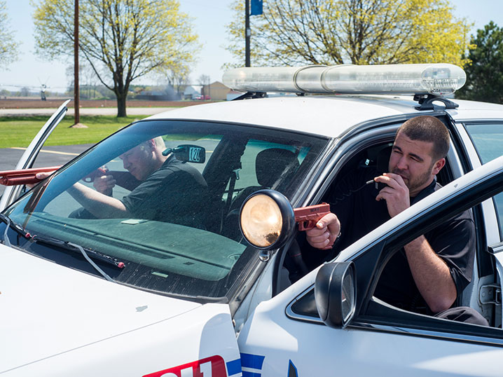 law enforcement academy students practicing skills in squad car